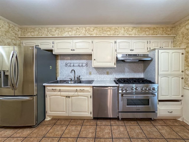 kitchen with tile patterned flooring, crown molding, sink, and appliances with stainless steel finishes