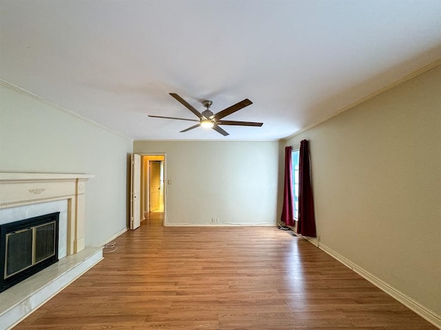 unfurnished living room with ceiling fan, ornamental molding, and light hardwood / wood-style flooring