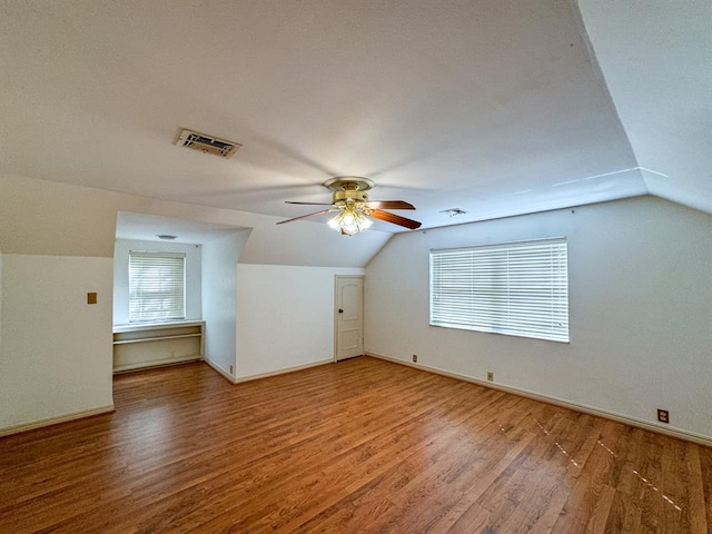 additional living space with hardwood / wood-style floors, ceiling fan, and vaulted ceiling