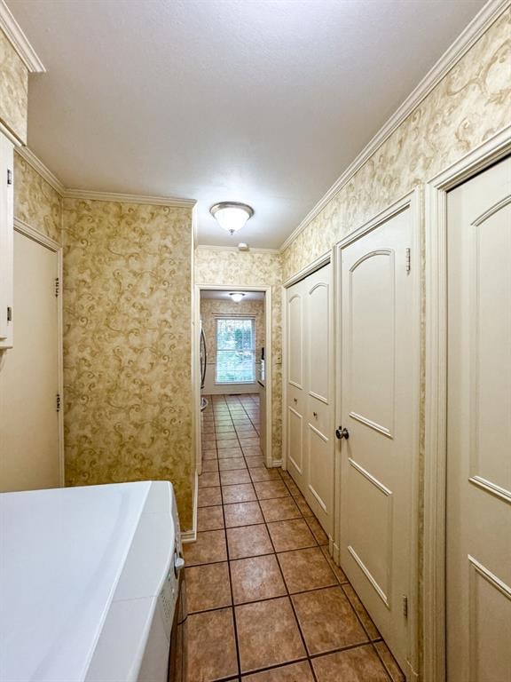 hall featuring tile patterned flooring, washer / dryer, and crown molding