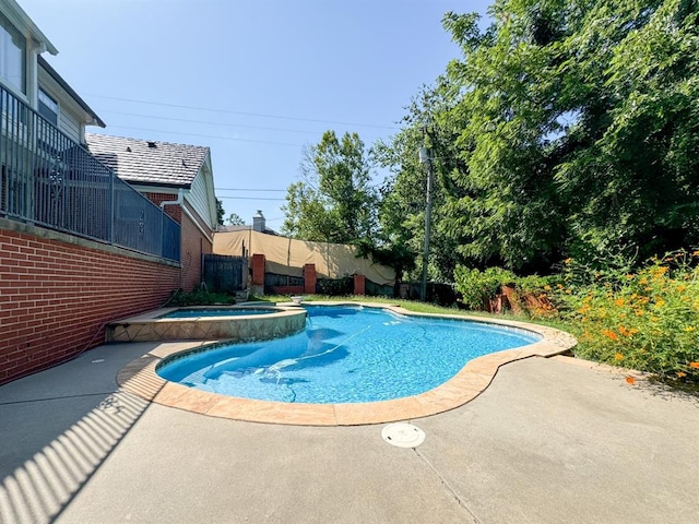 view of swimming pool with an in ground hot tub