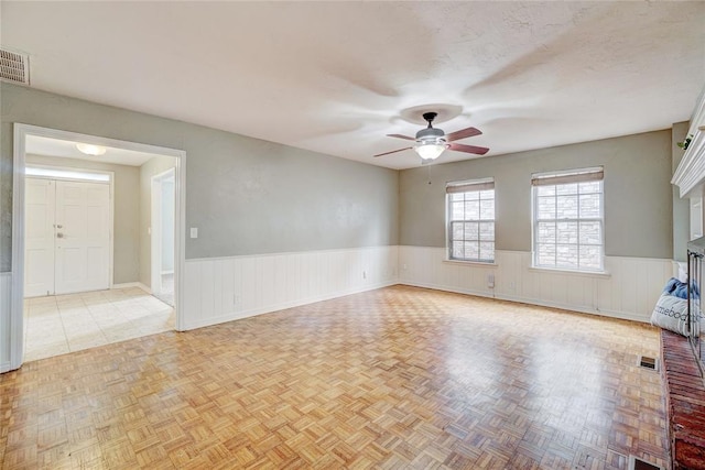 unfurnished room featuring ceiling fan, a fireplace, and light tile patterned floors