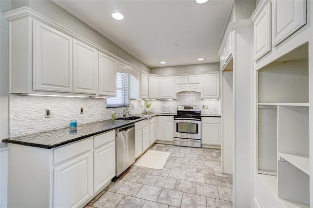 kitchen with backsplash, stainless steel appliances, white cabinetry, and sink