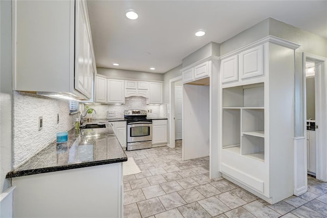 kitchen featuring tasteful backsplash, dark stone counters, sink, white cabinets, and stainless steel electric range oven