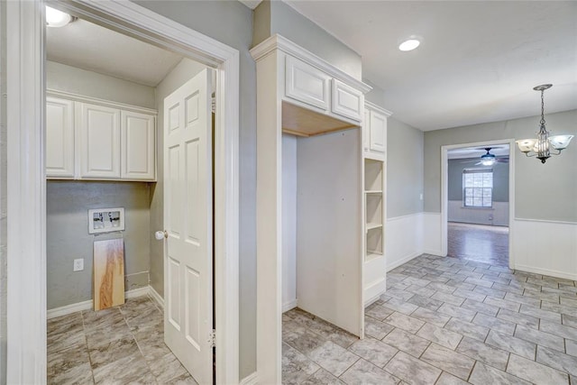 kitchen with white cabinets, hanging light fixtures, and ceiling fan with notable chandelier