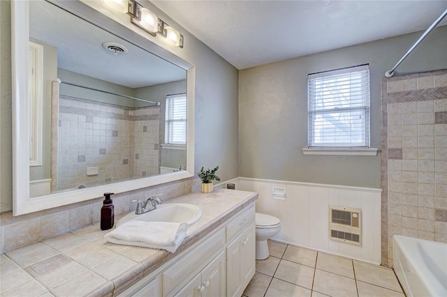 full bathroom with vanity, tiled shower / bath, tile patterned flooring, toilet, and heating unit