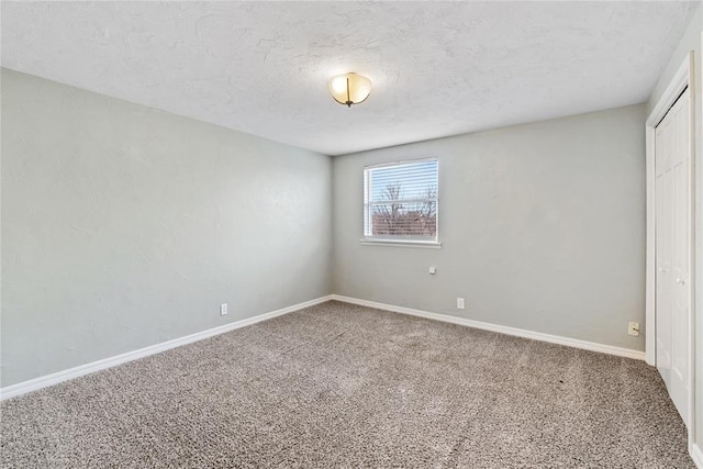 unfurnished room with carpet floors and a textured ceiling