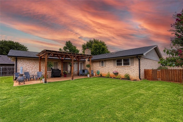 back house at dusk with a pergola, a lawn, and a patio