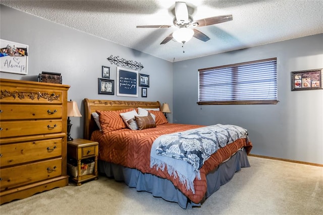 carpeted bedroom with ceiling fan and a textured ceiling