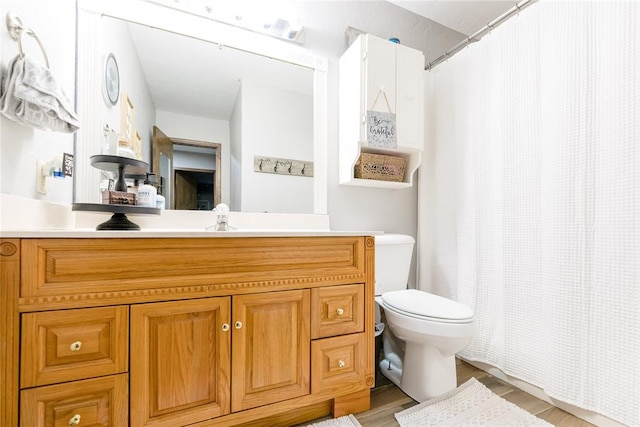 bathroom with hardwood / wood-style floors, vanity, and toilet