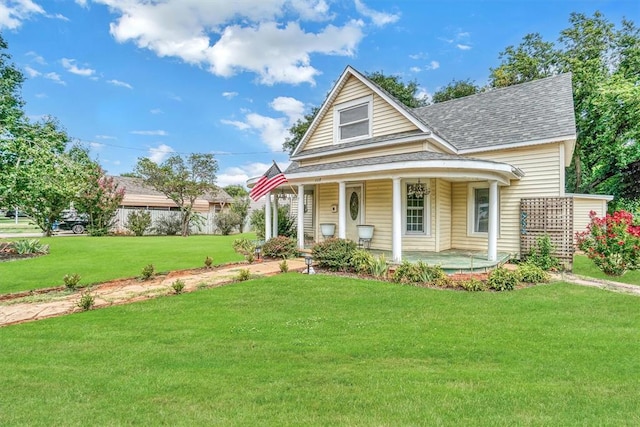 117 W 6th St, Cordell, OK 73632 - view of front of property with a front yard, covered porch, and a shingled roof