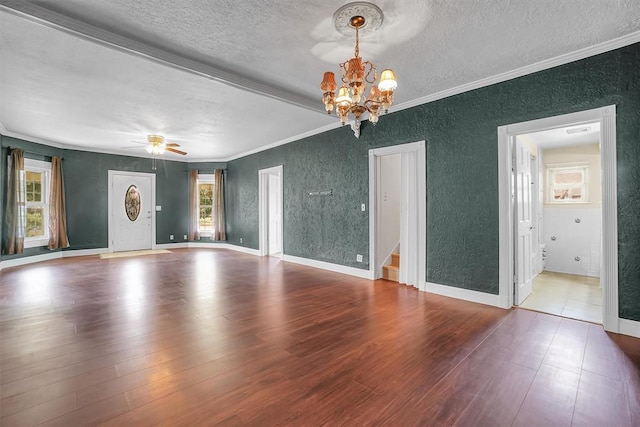 unfurnished living room with a textured ceiling, ornamental molding, ceiling fan with notable chandelier, and hardwood / wood-style flooring