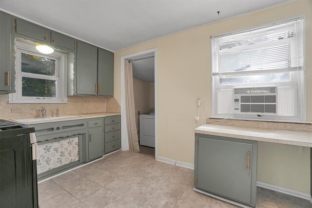 117 W 6th St, Cordell, OK 73632 - kitchen featuring washer / dryer, range, gray cabinets, light countertops, and ornamental molding
