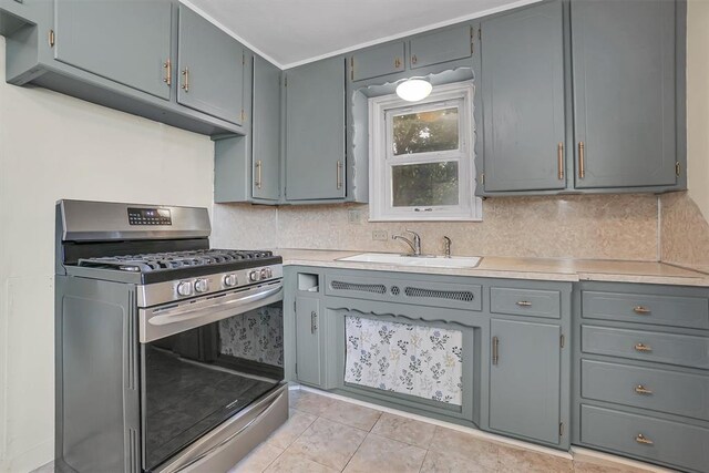 117 W 6th St, Cordell, OK 73632 - kitchen featuring stainless steel range with gas cooktop, light countertops, tasteful backsplash, and light tile patterned floors