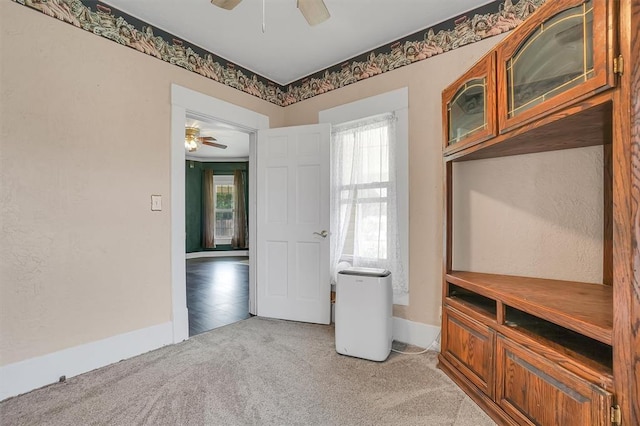 interior space with light carpet and ceiling fan