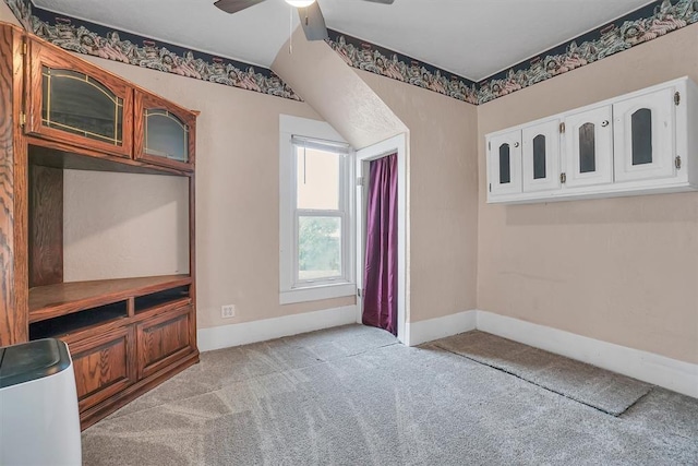 interior space with ceiling fan, light colored carpet, and lofted ceiling