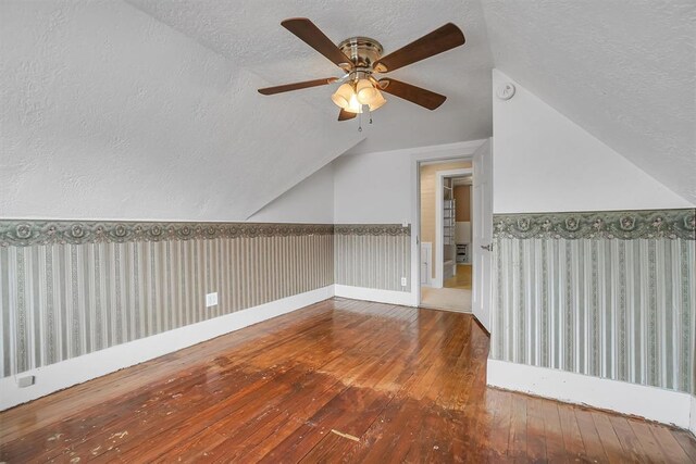 117 W 6th St, Cordell, OK 73632 - bonus room featuring wood-type flooring, a textured ceiling, vaulted ceiling, and a ceiling fan