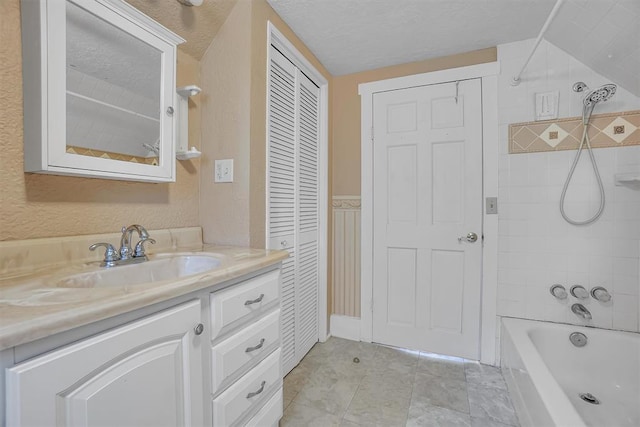 117 W 6th St, Cordell, OK 73632 - bathroom with vanity, a closet,  shower combination, a textured ceiling, and a textured wall