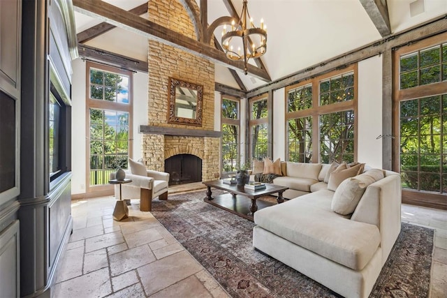 sunroom / solarium featuring vaulted ceiling with beams, a fireplace, and a notable chandelier