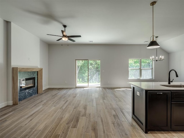 kitchen with hanging light fixtures, light hardwood / wood-style floors, sink, and a wealth of natural light