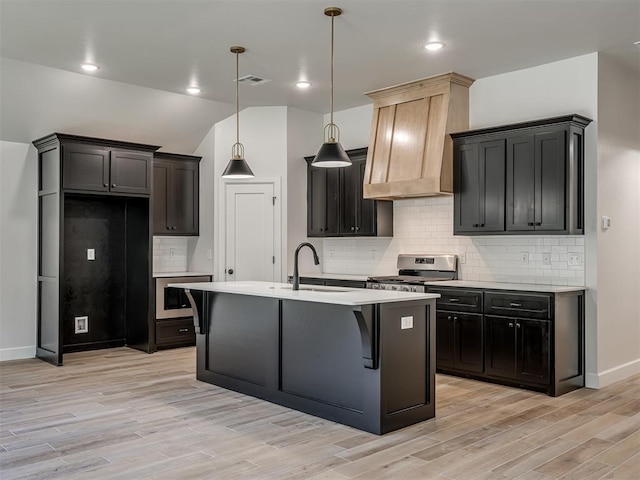 kitchen with light hardwood / wood-style flooring, custom range hood, sink, and stainless steel gas range