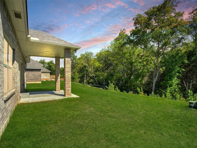 yard at dusk featuring a patio area