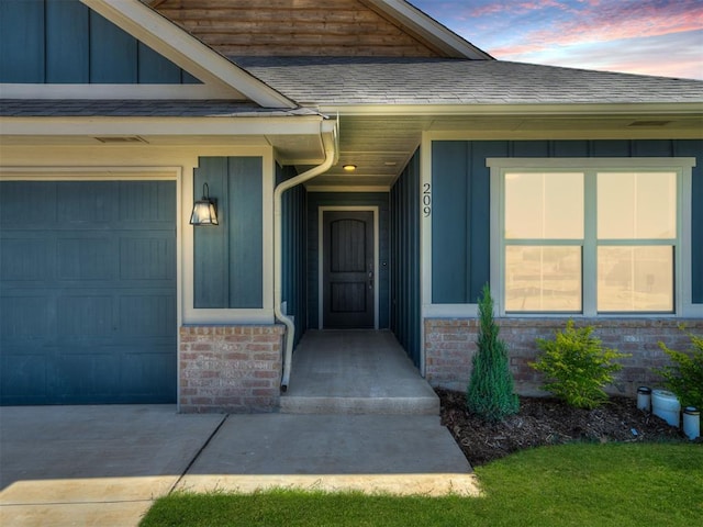 exterior entry at dusk featuring a garage