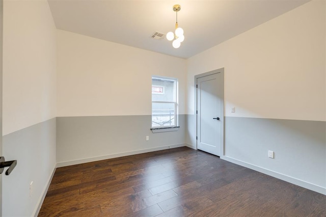 unfurnished room featuring dark hardwood / wood-style flooring and a chandelier