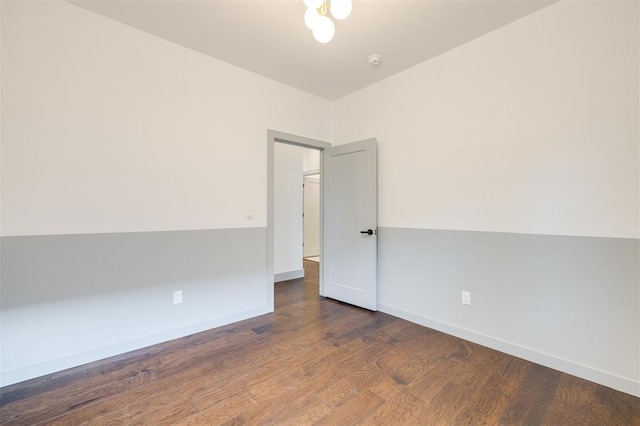 spare room with dark hardwood / wood-style flooring and vaulted ceiling