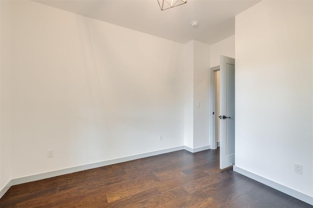 unfurnished room with dark hardwood / wood-style flooring