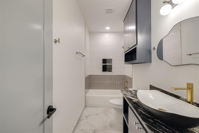 full bathroom featuring vanity, tiled shower / bath combo, and toilet