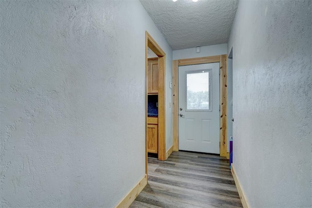 doorway to outside with a textured ceiling and hardwood / wood-style flooring