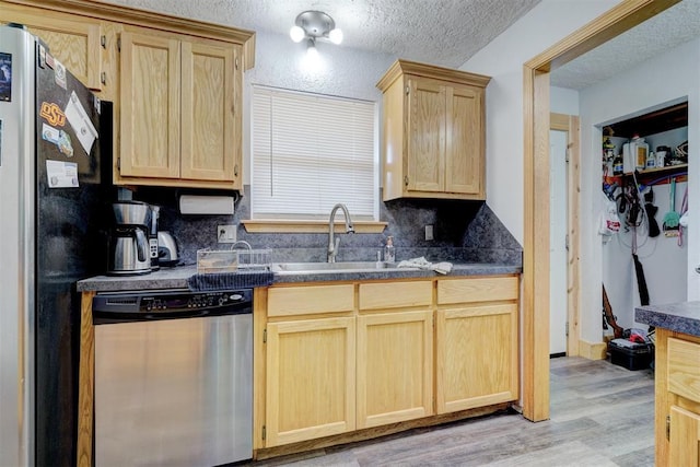 kitchen featuring light brown cabinets, sink, light wood-type flooring, a textured ceiling, and stainless steel appliances