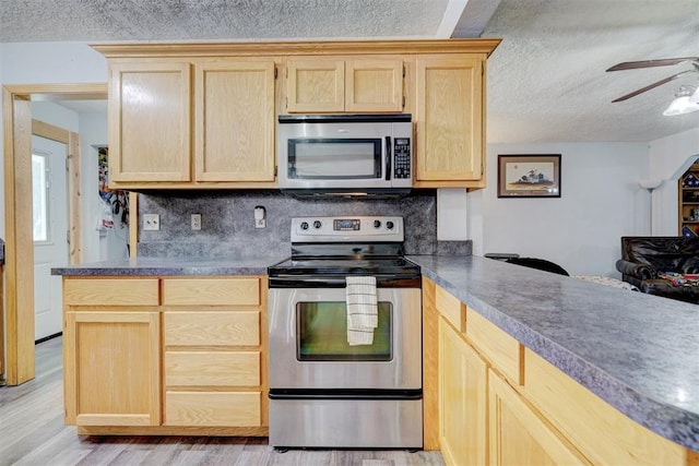 kitchen with light brown cabinets, light hardwood / wood-style floors, a textured ceiling, and appliances with stainless steel finishes