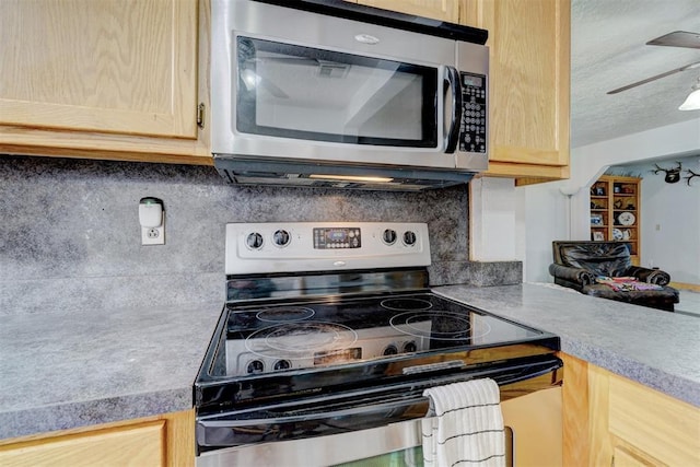 kitchen featuring ceiling fan, light brown cabinets, backsplash, and appliances with stainless steel finishes