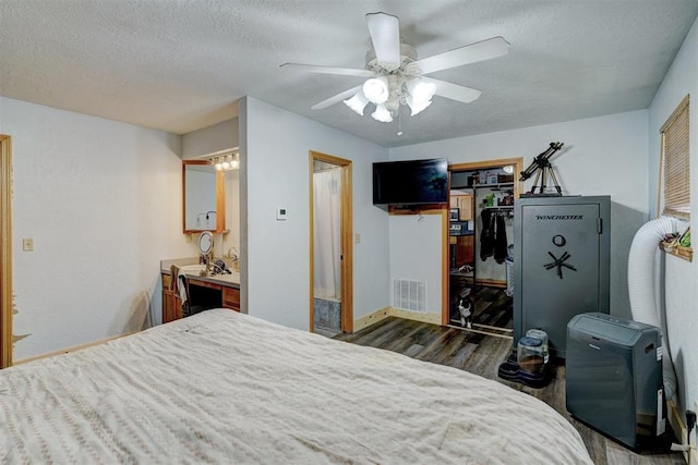 bedroom with ceiling fan, dark hardwood / wood-style floors, a textured ceiling, and a closet