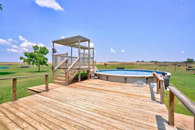 wooden deck with a pergola, a lawn, a rural view, and a fenced in pool