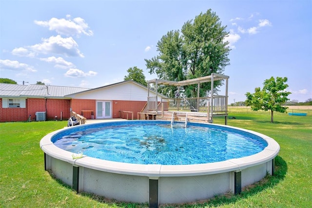 view of swimming pool featuring a yard, french doors, a pergola, central AC, and a wooden deck