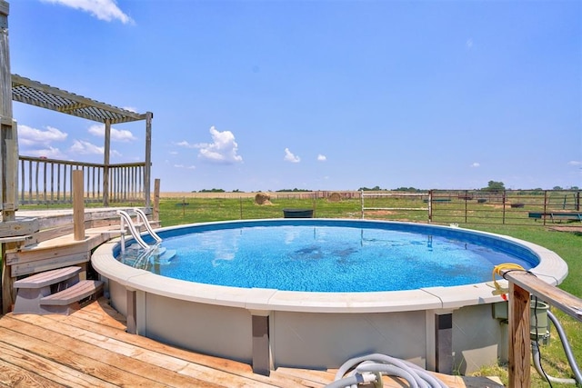 view of pool with a rural view, a pergola, and a wooden deck