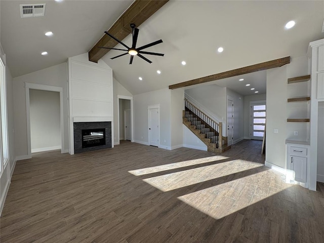 living room with beam ceiling, ceiling fan, dark wood-type flooring, a multi sided fireplace, and high vaulted ceiling