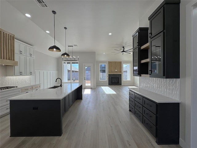 kitchen featuring white cabinets, gas stovetop, sink, and tasteful backsplash