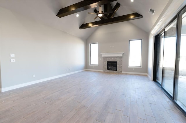 unfurnished living room featuring a stone fireplace, high vaulted ceiling, light hardwood / wood-style flooring, ceiling fan, and beam ceiling