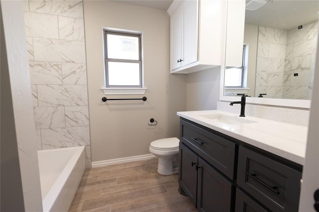 full bathroom with a healthy amount of sunlight, vanity, toilet, and tiled shower / bath