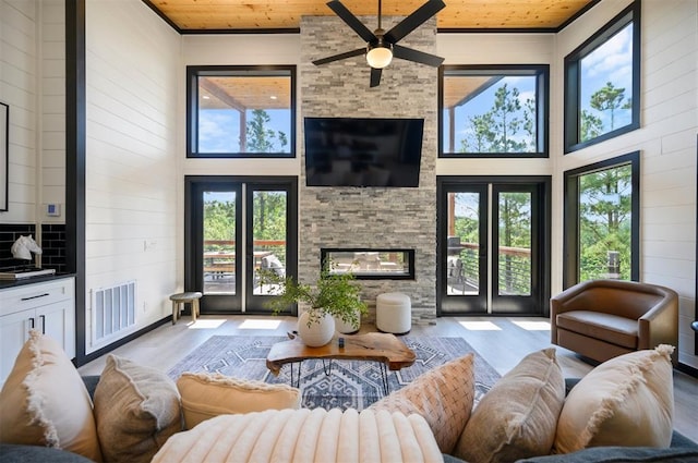 living room with a wealth of natural light, light hardwood / wood-style flooring, and wooden ceiling