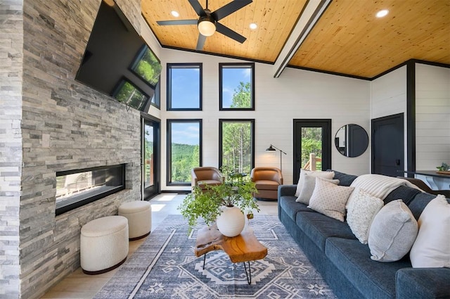 living room with hardwood / wood-style floors, wooden ceiling, high vaulted ceiling, a fireplace, and beam ceiling