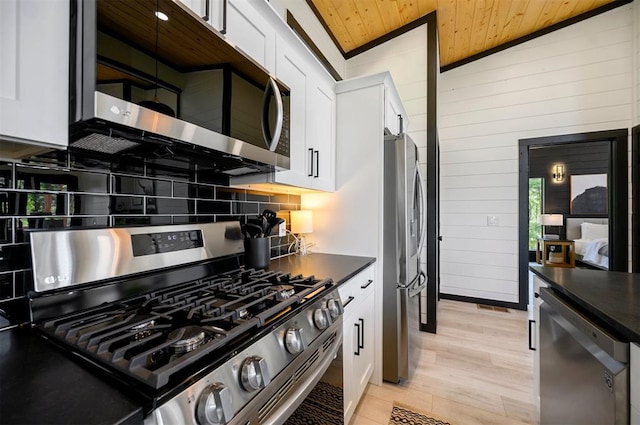 kitchen with appliances with stainless steel finishes, white cabinetry, vaulted ceiling, and wooden ceiling