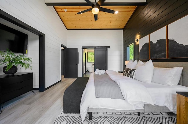 bedroom featuring a barn door, light hardwood / wood-style floors, ceiling fan, and wood ceiling