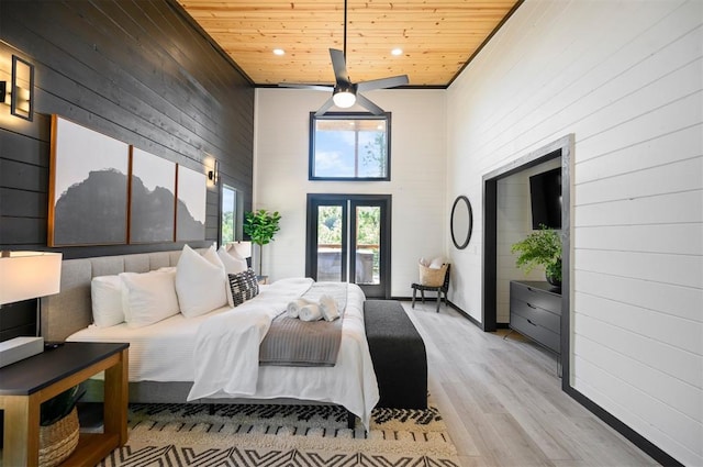 bedroom with french doors, wooden ceiling, a high ceiling, and light wood-type flooring