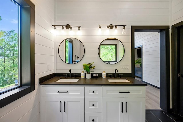 bathroom with vanity and wood walls