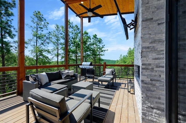 deck with outdoor lounge area, area for grilling, and ceiling fan